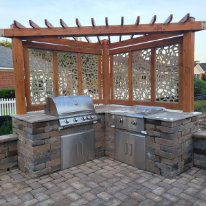 outdoor kitchen with stainless steel appliances with a pergola in myrtle beach