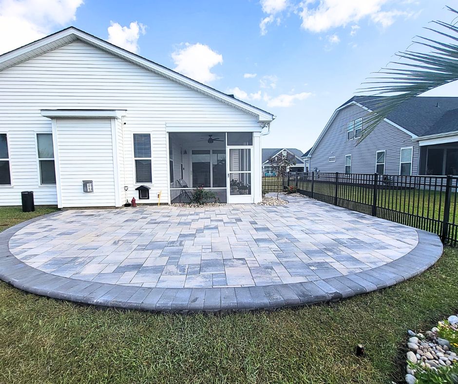 round paver patios in a mix of gray and beige colors with a white house in the background