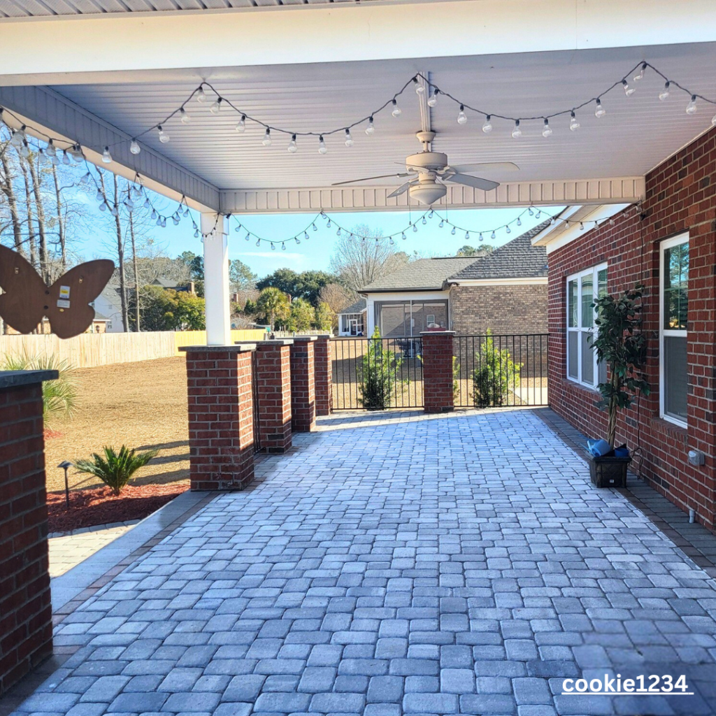 paver patio with brick pillars and an aluminum fence with outdoor lighting in Myrtle Beach