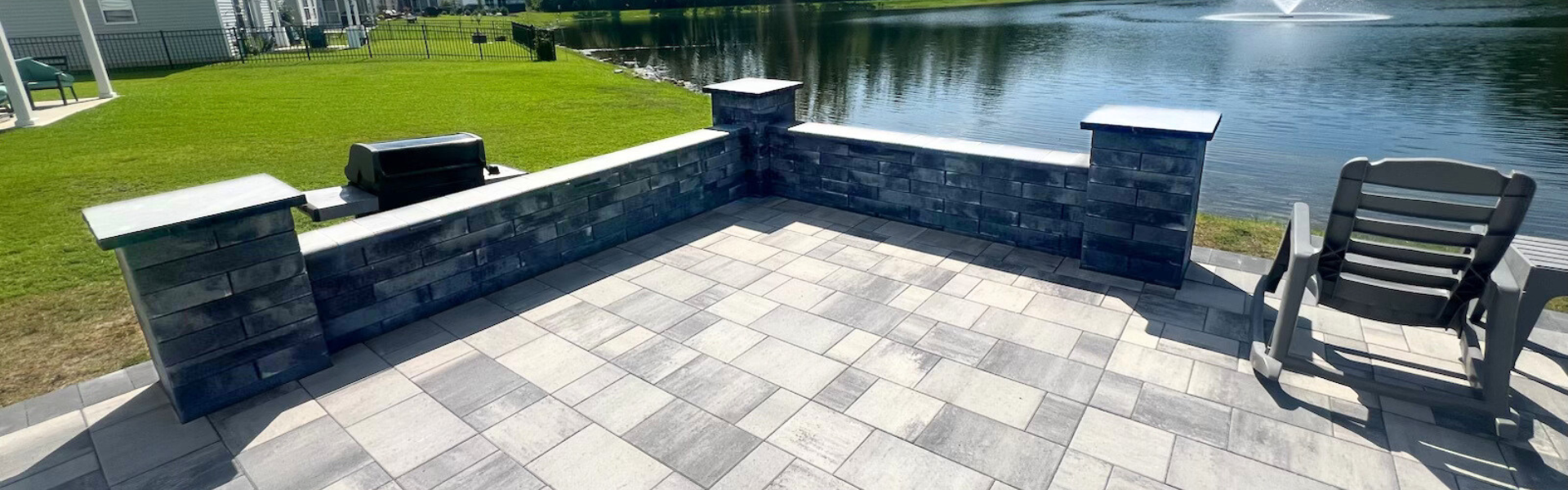 paver patio on the river with hardscape sitting bench installed by elite coastal landscaping