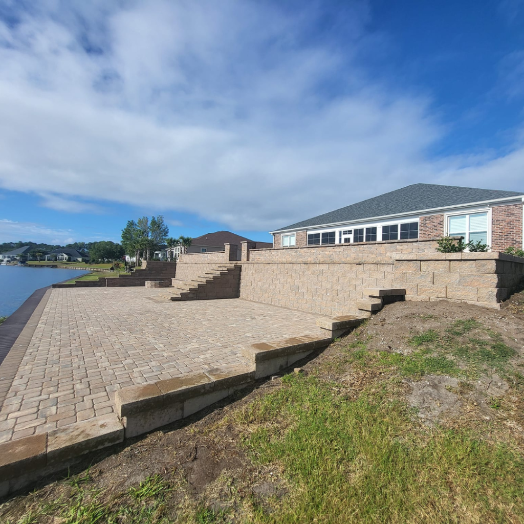 retaining wall with steps for the yard in front of lake with drainage solutions in myrtle beach